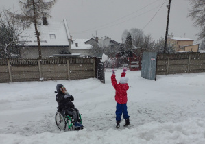 Dwoje uczniów bawiących się na śniegu